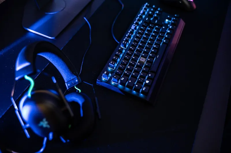 Área de gaming com estações equipadas com hardware de alta qualidade, cadeiras Noblechair e secretárias Leetdesk ajustáveis